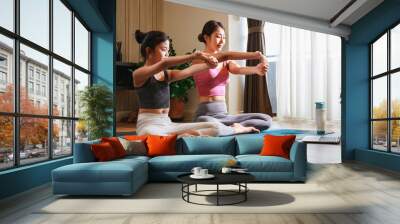 Asian woman and Little girl practicing yoga from yoga online course via laptop at home. Healthy lifestyle - technology at home Wall mural