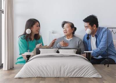 Asian Senior old woman on the bed with doctor and her son in hospital Wall mural