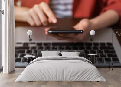 Woman hand using smartphone and laptop on the table in office. Wall mural