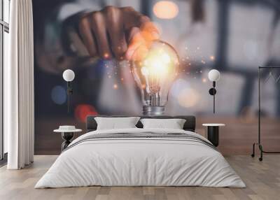 Human hand pointing at a light bulb,Finding new solutions to solve business problems,innovation and brain power from brainstorming,Finding Creativity and Inspiration,successful business ideas Wall mural