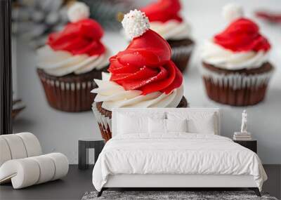 Two cupcakes with holly and red berries, candy cane decorations on top of the frosting Wall mural