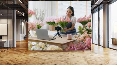 Asia girl vlogger influencer or SME owner people smile work on home video camera selfie shoot filming for live sell show happy talk on mobile VoIP app. Remote sale product at modern florist gift shop. Wall mural