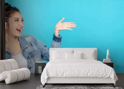 Banner of Happy asian woman feeling happiness and gesture hand open on blue background. Cute asia girl smiling wearing casual jeans shirt and present on copy space. Wall mural