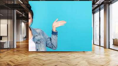 Banner of Happy asian woman feeling happiness and gesture hand open on blue background. Cute asia girl smiling wearing casual jeans shirt and present on copy space. Wall mural