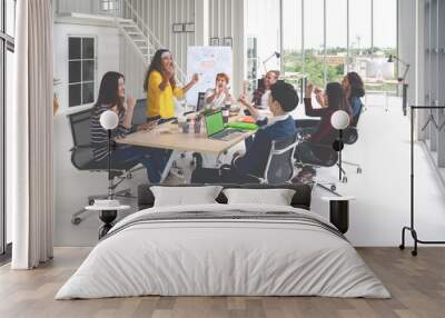 Group of young attractive asian creative design team meeting at office celebrating success or winner. Asian employee engaged together with effective and productive meeting and happy workplace concept. Wall mural