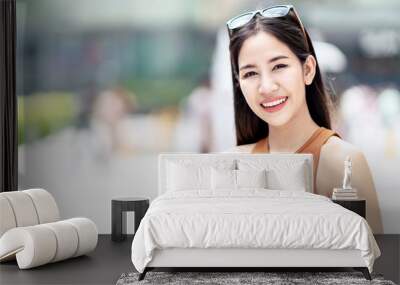 Portrait of young happy attractive asian woman smiling to camera at city background in concept of beauty skin care uv sun screen protection. Beautiful sexy asian stylish feeling relax and positive. Wall mural