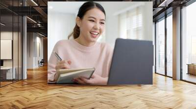 Young attractive business asian woman talking about sale report in video call conference on notebook computer online meeting in working from home, Working remotely and Social isolation concept. Wall mural