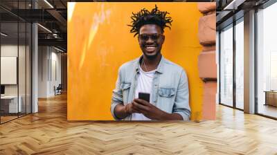 Portrait of handsome, smiling afro man using his mobile phone. Wall mural