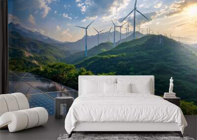 Solar panels and wind turbines against a mountainous landscape, with a blue sky and clouds Wall mural