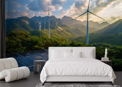 Solar panels and wind turbines against a mountainous landscape, with a blue sky and clouds Wall mural