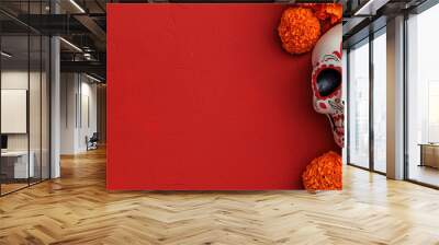 vibrant Dia de Muertos altar featuring decorative skull surrounded by bright marigold flowers against rich red background, celebrating life and remembrance Wall mural