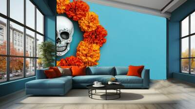 vibrant marigold wreath surrounds decorative skull, creating striking contrast against blue background. arrangement includes candle, evoking festive and celebratory atmosphere Wall mural