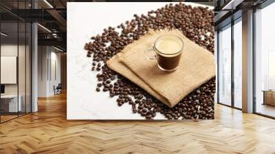 Cup of espresso coffee and coffee beans, on brown napkin, on white marble table Wall mural