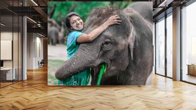 Girl having fun with elephants at Patara Elephant Farm, Chiang Mai, Thailand Wall mural