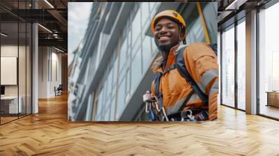 A candid portrait of a black African smiling industrial climber. The man in the orange jacket is a professional window cleaner in skyscrapers Wall mural