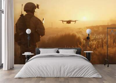 A man in a military uniform controls a military drone over a field at sunset. A scout soldier uses modern technology in combat Wall mural