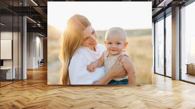 Mom holding smiling baby boy. Wall mural