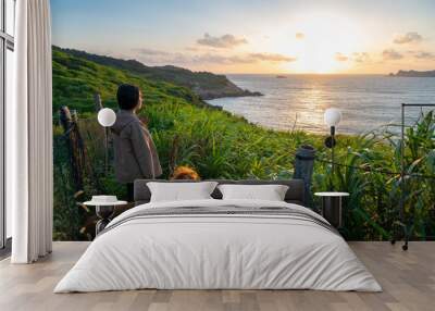 Golden Retriever accompanies the owner to watch the sunrise on the beach Wall mural