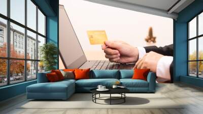 Close-up Of A Man's Hand Holding Gold Credit Card During Using Laptop. Business concept and Online concept Wall mural