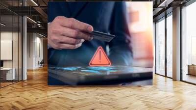 risk and online shopping payment transaction concept, businessman using tablet and credit card making purchase on website or application platform with caution triangle sign Wall mural