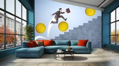 Businessman running up stairs with coins Wall mural