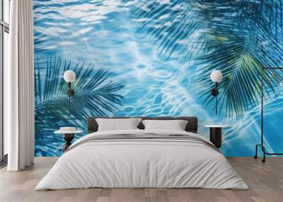 Tropical palm leaves in the water on a blue background with a place to copy text. The concept of recreation, tourism and sea travel. Wall mural