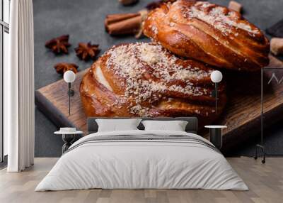 Delicious fresh crispy cinnamon buns sprinkled with coconut crumbs on a wooden cutting board Wall mural