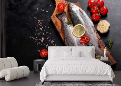 Raw trout lie on a black stone chopping board on a dark concrete table Wall mural