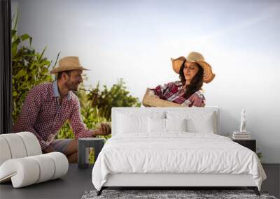 Happy farmers couple on vegetables in the farm. Wall mural