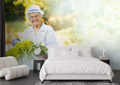 Happy senior woman gardening in her backyard garden Wall mural