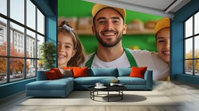 A cheerful group of three, including two children and an adult, poses in a vibrant green cafe, all wearing matching hats and smiles. Wall mural