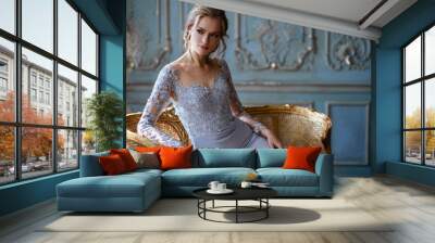 Young blonde bride woman in a light blue wedding dress, fashion beauty portrait in interior Wall mural