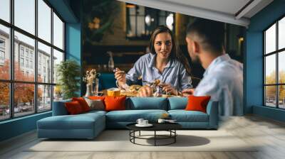 A happy young couple having dinner at a fancy restaurant Wall mural