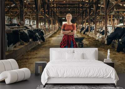 Beautiful Caucasian cowgirl loves domestic lifestyle. She sands in a stable. Wall mural