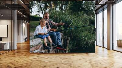 boy fishing on the lake with his grandfather Wall mural