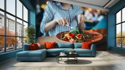 close up of woman in restaurant eating Wall mural