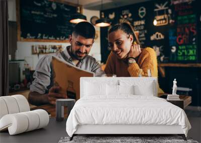 couple ordering food looking at menu in food corner bar Wall mural