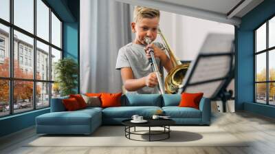 Cute Caucasian boy practicing trombone. Wall mural