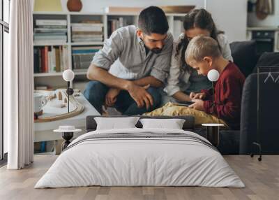 cute young family using tablet together at home Wall mural