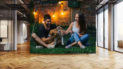 friends playing with their dog outdoor at home backyard. night scene Wall mural