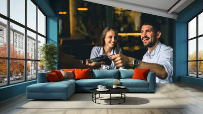 man paying contactless with visa or master card in restaurant Wall mural