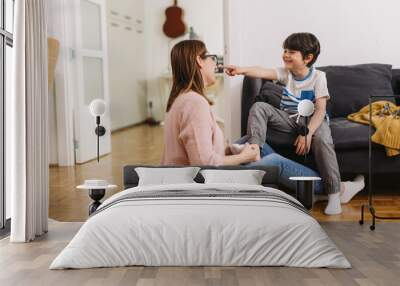 mother helps her son to puts on socks Wall mural