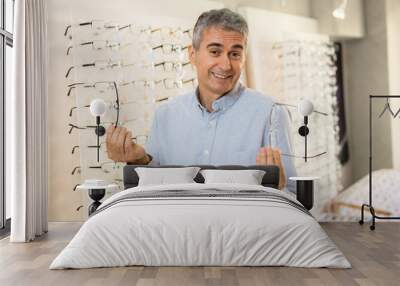 senior man choosing glasses in optic store Wall mural