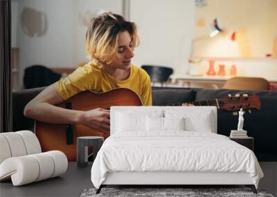 teenage boy playing acoustic guitar at home Wall mural