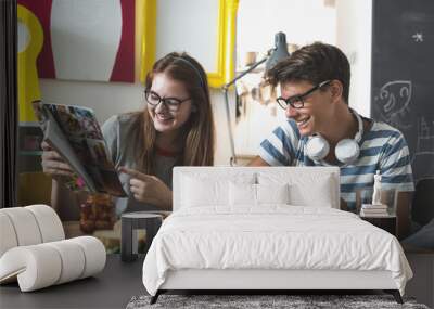 Teenagers having fun reading magazine at their home Wall mural