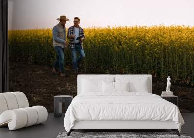 Two farmers discussing business while taking a walk on their filled. Wall mural