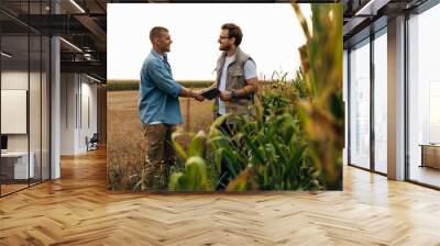 View form the corn field of two men shaking hands. Wall mural