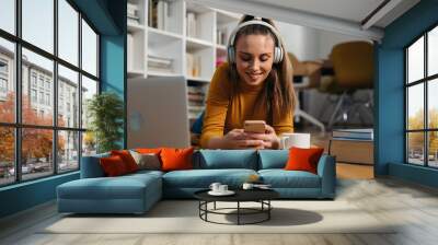 woman listening music on headphones at home Wall mural