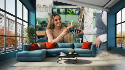 woman paying contactless with card in cafeteria Wall mural