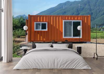 Orange shipping container near the mountains Wall mural